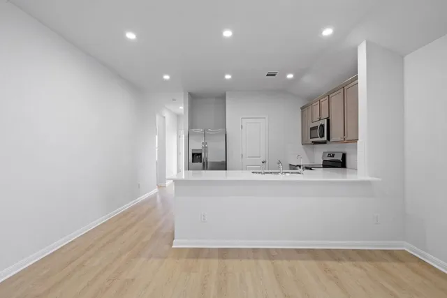 a view of kitchen with stainless steel appliances cabinets