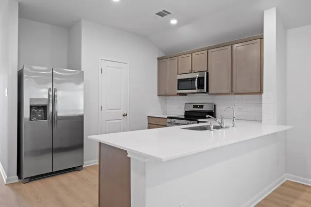 a kitchen with a refrigerator stove and microwave