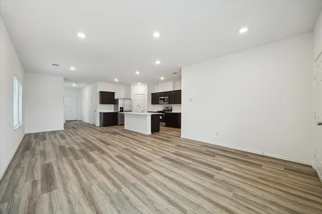 a view of kitchen with kitchen island wooden floor center island and stainless steel appliances