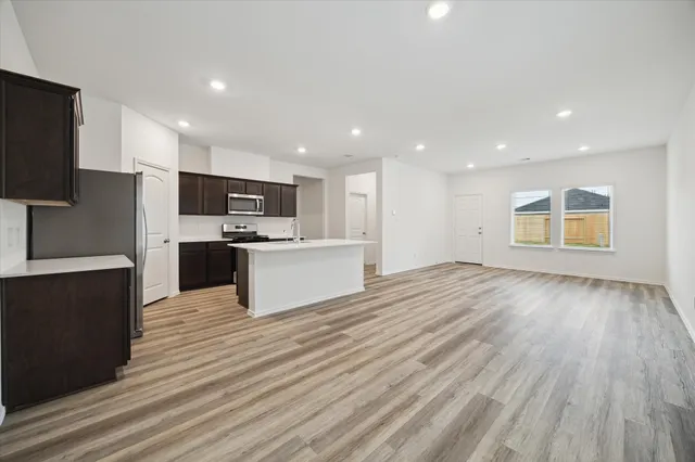a view of kitchen with granite countertop cabinets and refrigerator