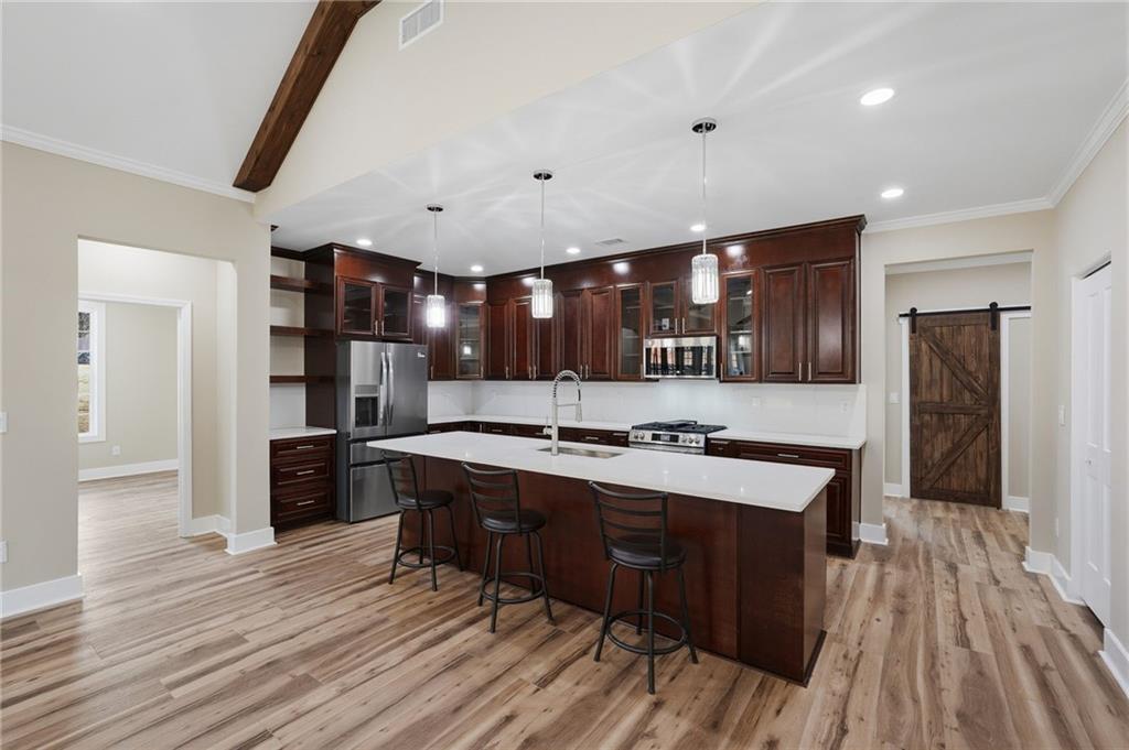 2322 Rockbridge Road Southwest Stone Mountain, GA 30087 - Photo 13 of 46 a large kitchen with stainless steel appliances a large counter top a stove and a refrigerator