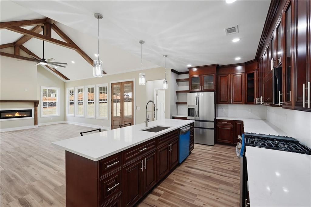 2322 Rockbridge Road Southwest Stone Mountain, GA 30087 - Photo 16 of 46 a kitchen with stainless steel appliances granite countertop a sink a stove and a wooden floors