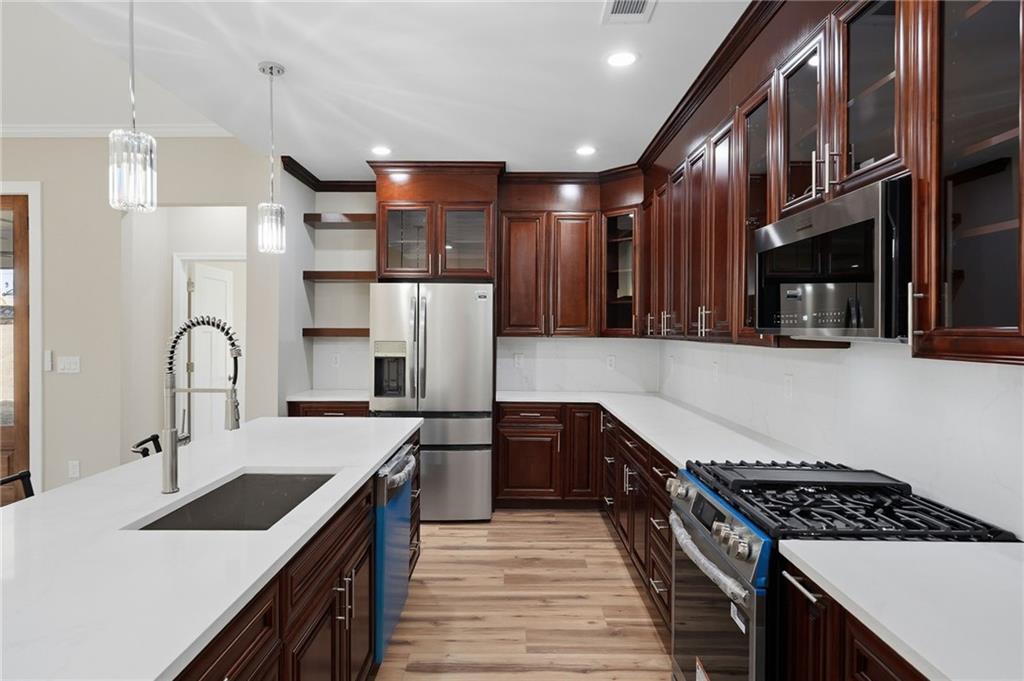 2322 Rockbridge Road Southwest Stone Mountain, GA 30087 - Photo 17 of 46 a kitchen with kitchen island stainless steel appliances a sink stove and refrigerator