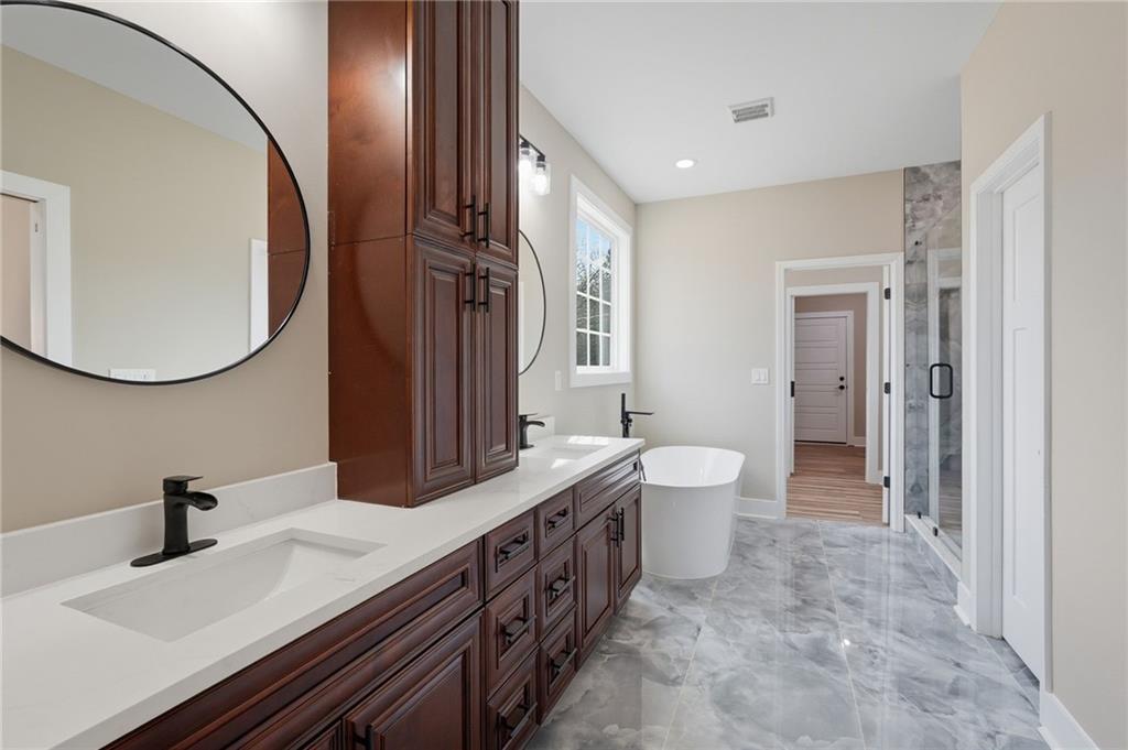 2322 Rockbridge Road Southwest Stone Mountain, GA 30087 - Photo 27 of 46 a spacious bathroom with a double vanity sink double mirror and toilet