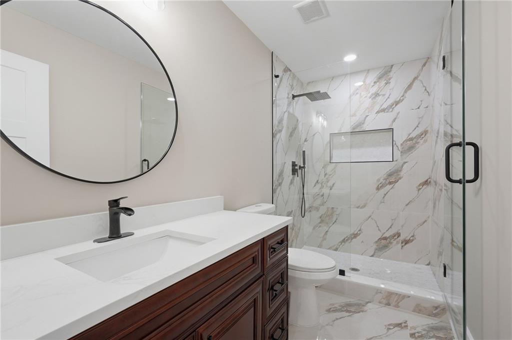 2322 Rockbridge Road Southwest Stone Mountain, GA 30087 - Photo 33 of 46 a bathroom with a sink a toilet and shower