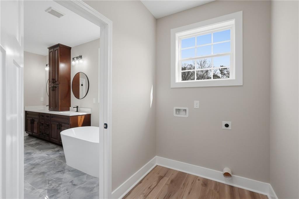 2322 Rockbridge Road Southwest Stone Mountain, GA 30087 - Photo 37 of 46 a bathroom with a toilet a sink and mirror