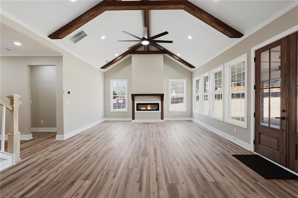 2322 Rockbridge Road Southwest Stone Mountain, GA 30087 - Photo 8 of 46 a view of a livingroom with wooden floor a ceiling fan and windows