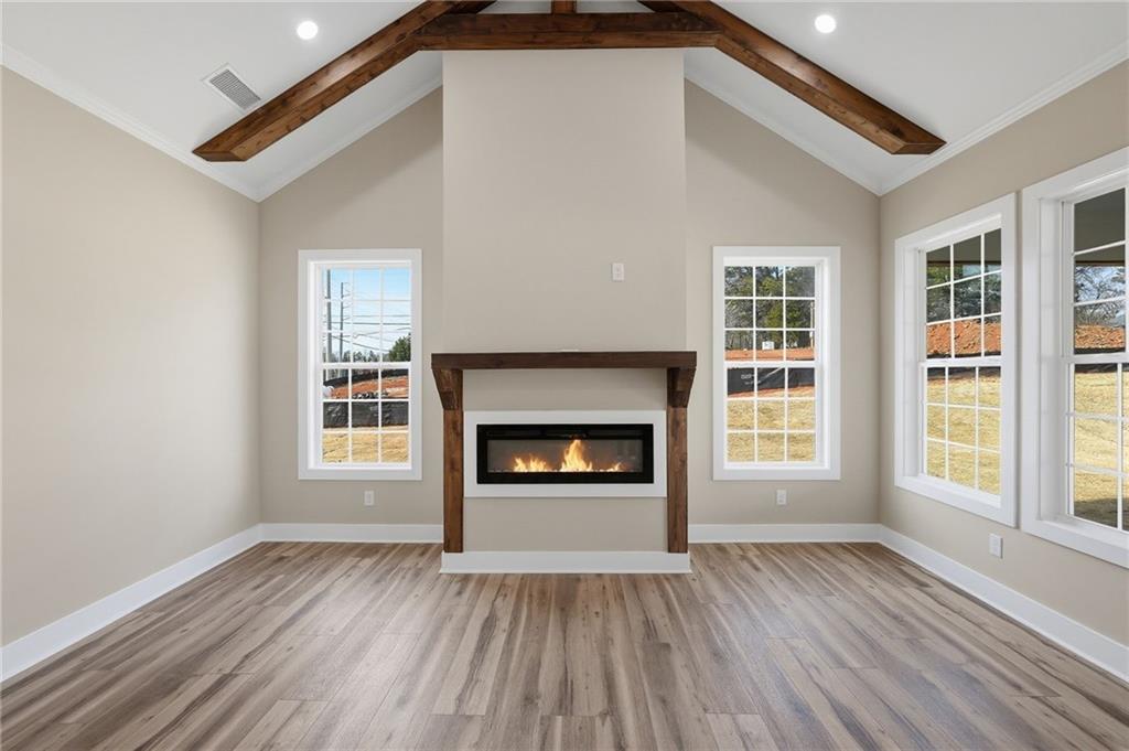 2322 Rockbridge Road Southwest Stone Mountain, GA 30087 - Photo 10 of 46 an empty room with wooden floor fireplace and windows