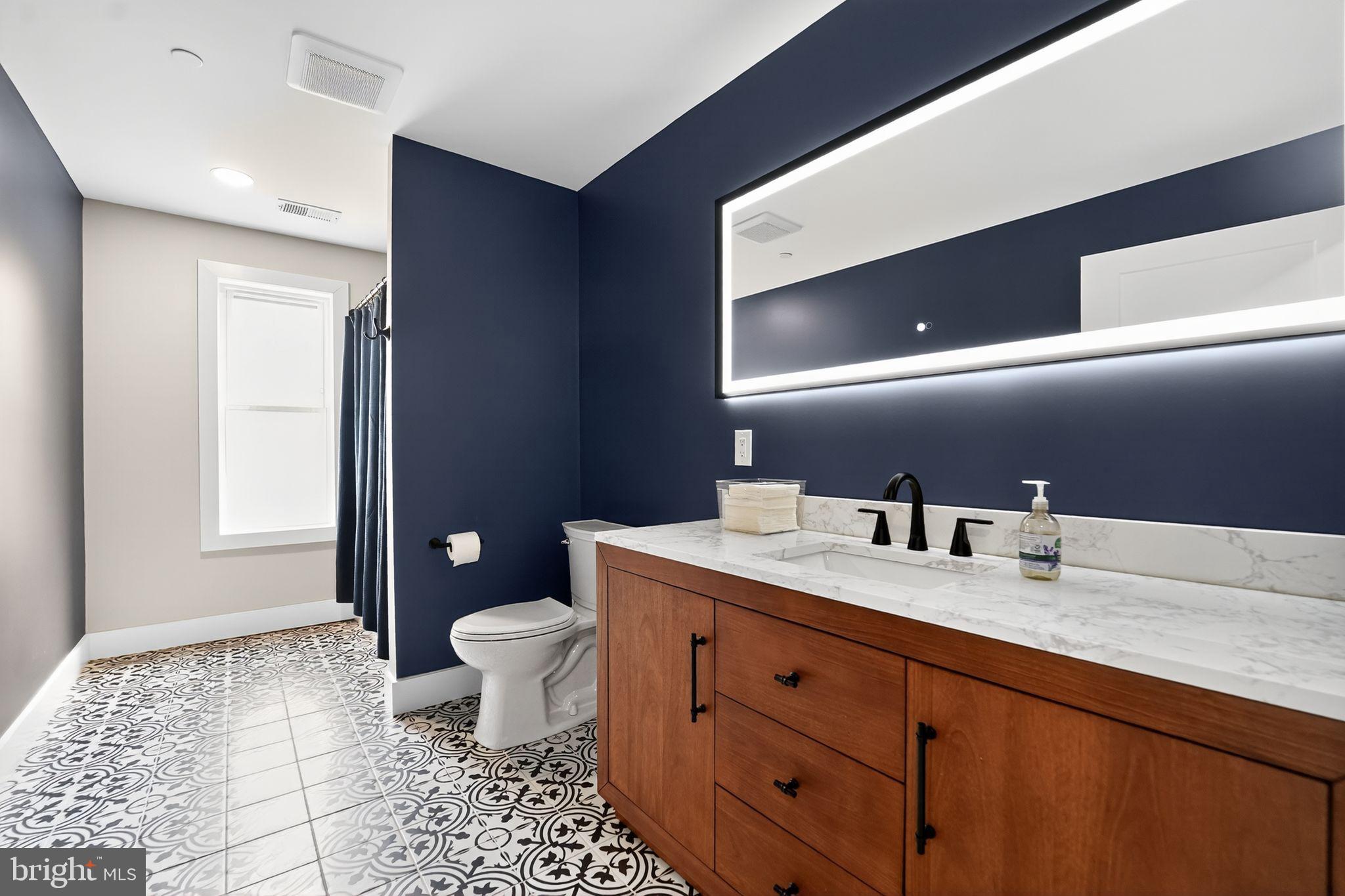 8305 Biggs Ford Road Walkersville, MD 21793 - Photo 24 of 38 a bathroom with a granite countertop sink a toilet and a mirror