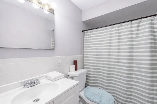 a bathroom with a sink a toilet and a mirror