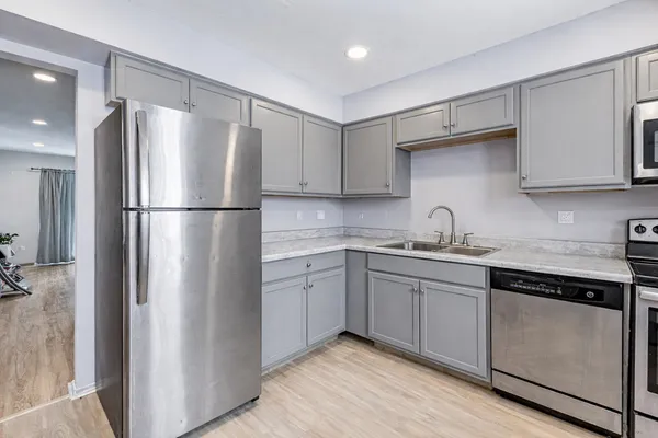 a kitchen with a refrigerator sink and cabinets