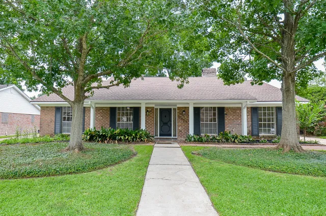 a front view of a house with a yard and potted plants