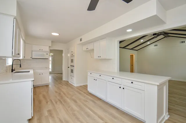a large white kitchen with cabinets