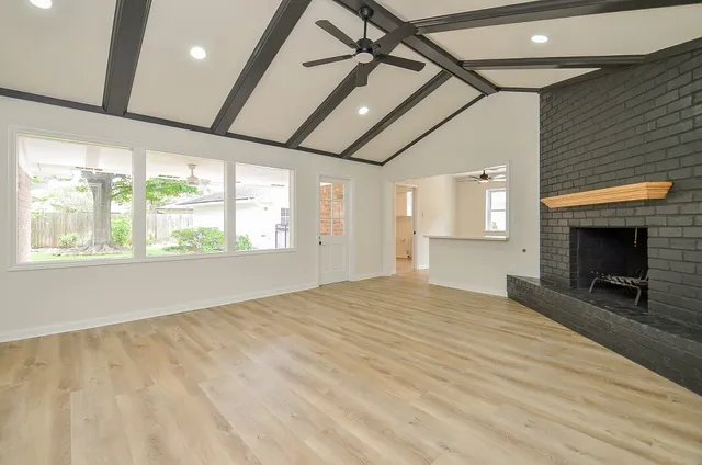 a view of empty room with wooden floor and fireplace