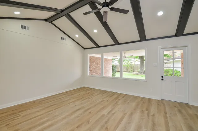 a view of an empty room with a fireplace and a window