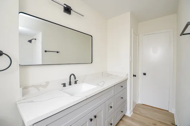 a bathroom with a double vanity sink a mirror and a toilet