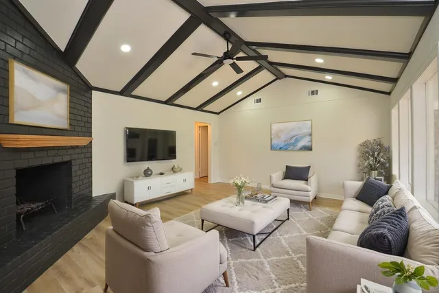 a living room with furniture a flat screen tv and a fireplace