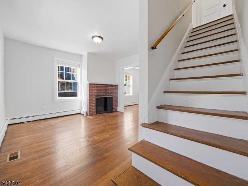 46 West End Avenue, Unit LEFT Summit, NJ 07901 - Photo 11 of 19 a view of an empty room with wooden floor fireplace and a window