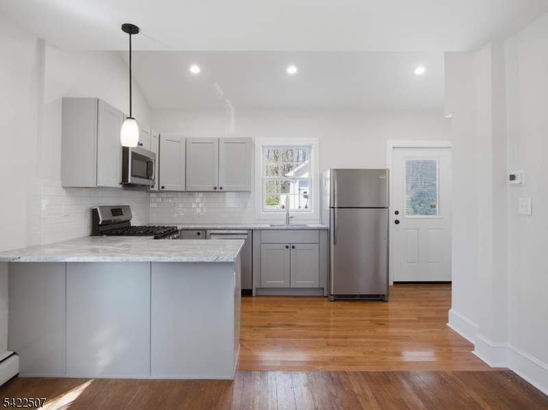 46 West End Avenue, Unit LEFT Summit, NJ 07901 - Photo 7 of 19 a kitchen with kitchen island white cabinets and stainless steel appliances