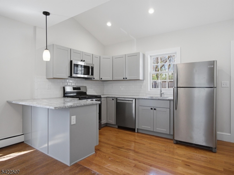 46 West End Avenue, Unit LEFT Summit, NJ 07901 - Photo 9 of 19 a kitchen with a refrigerator a microwave a sink and a stove
