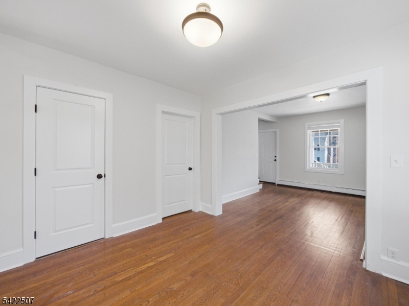 46 West End Avenue, Unit LEFT Summit, NJ 07901 - Photo 10 of 19 an empty room with wooden floor and windows