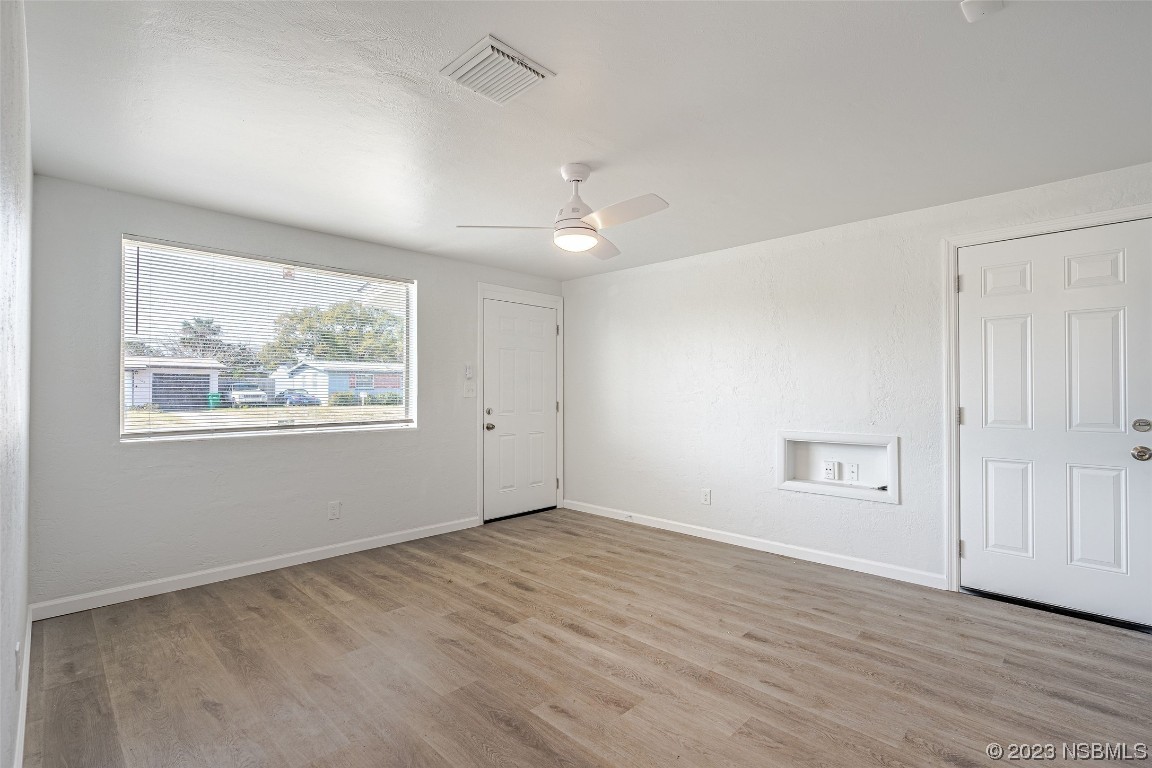 909 Derbyshire Road Daytona Beach, FL 32117 - Photo 12 of 18 wooden floor in an empty room with a window