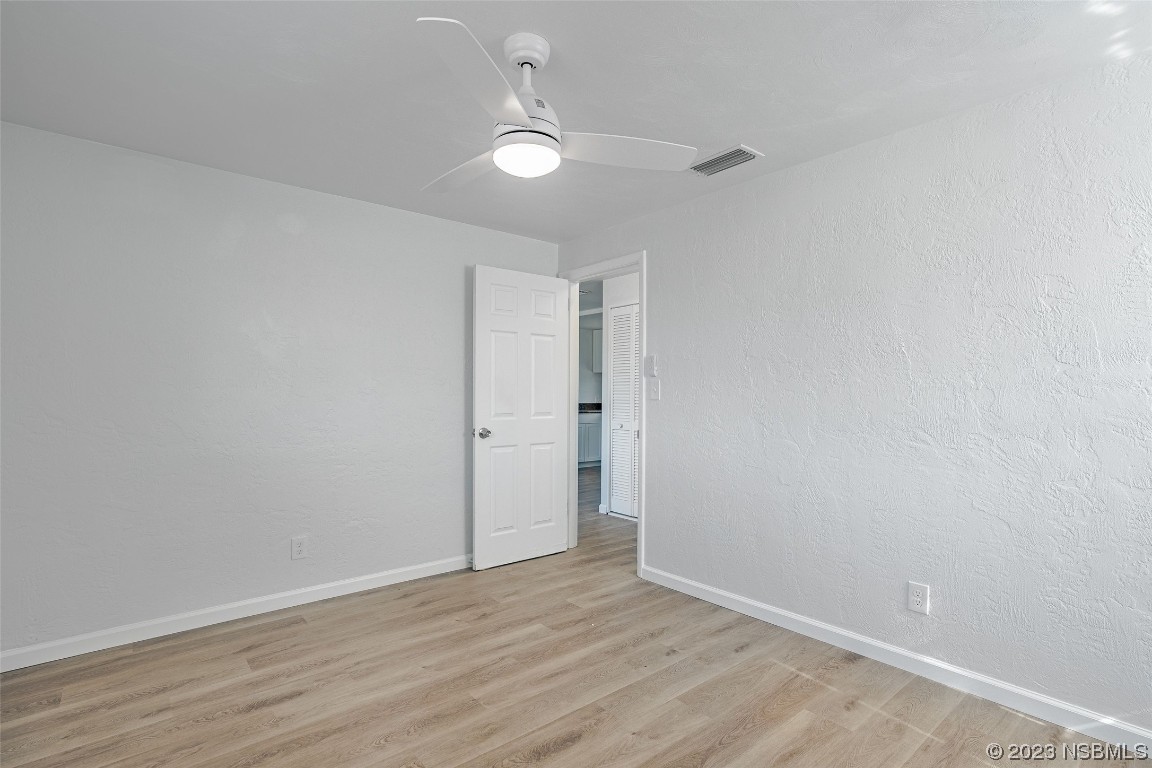 909 Derbyshire Road Daytona Beach, FL 32117 - Photo 13 of 18 a view of an empty room with wooden floor