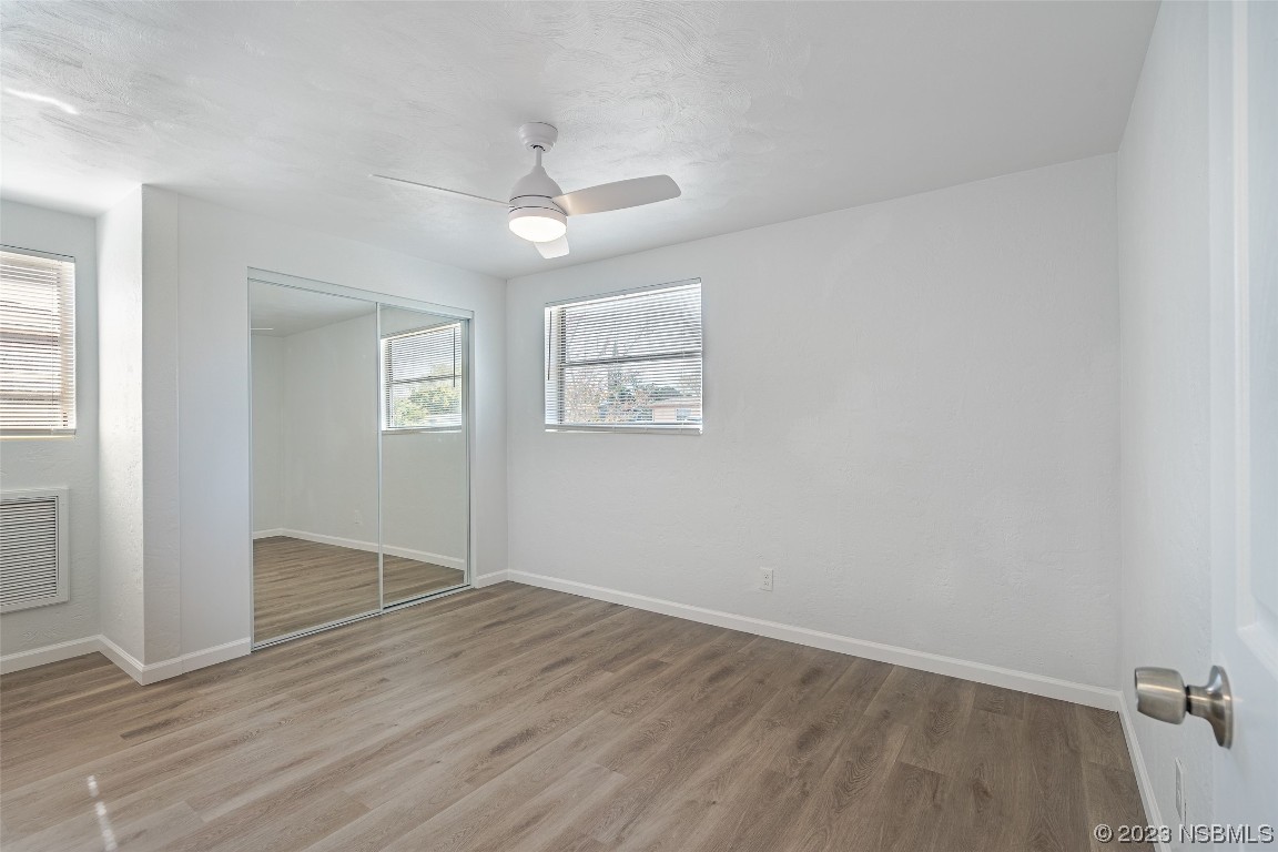 909 Derbyshire Road Daytona Beach, FL 32117 - Photo 15 of 18 wooden floor in an empty room with a window