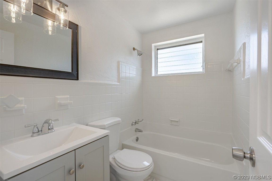 909 Derbyshire Road Daytona Beach, FL 32117 - Photo 16 of 18 a bathroom with a sink toilet a vanity and bathtub