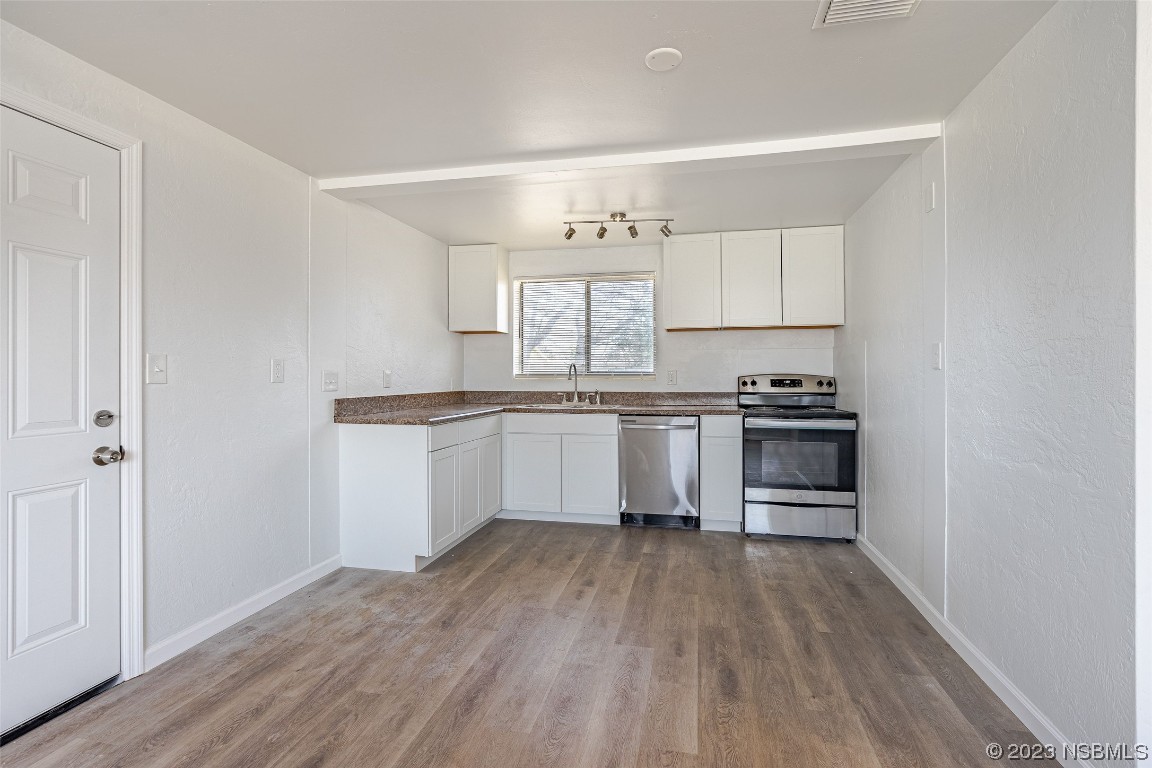 909 Derbyshire Road Daytona Beach, FL 32117 - Photo 7 of 18 a kitchen with granite countertop a sink cabinets and stainless steel appliances