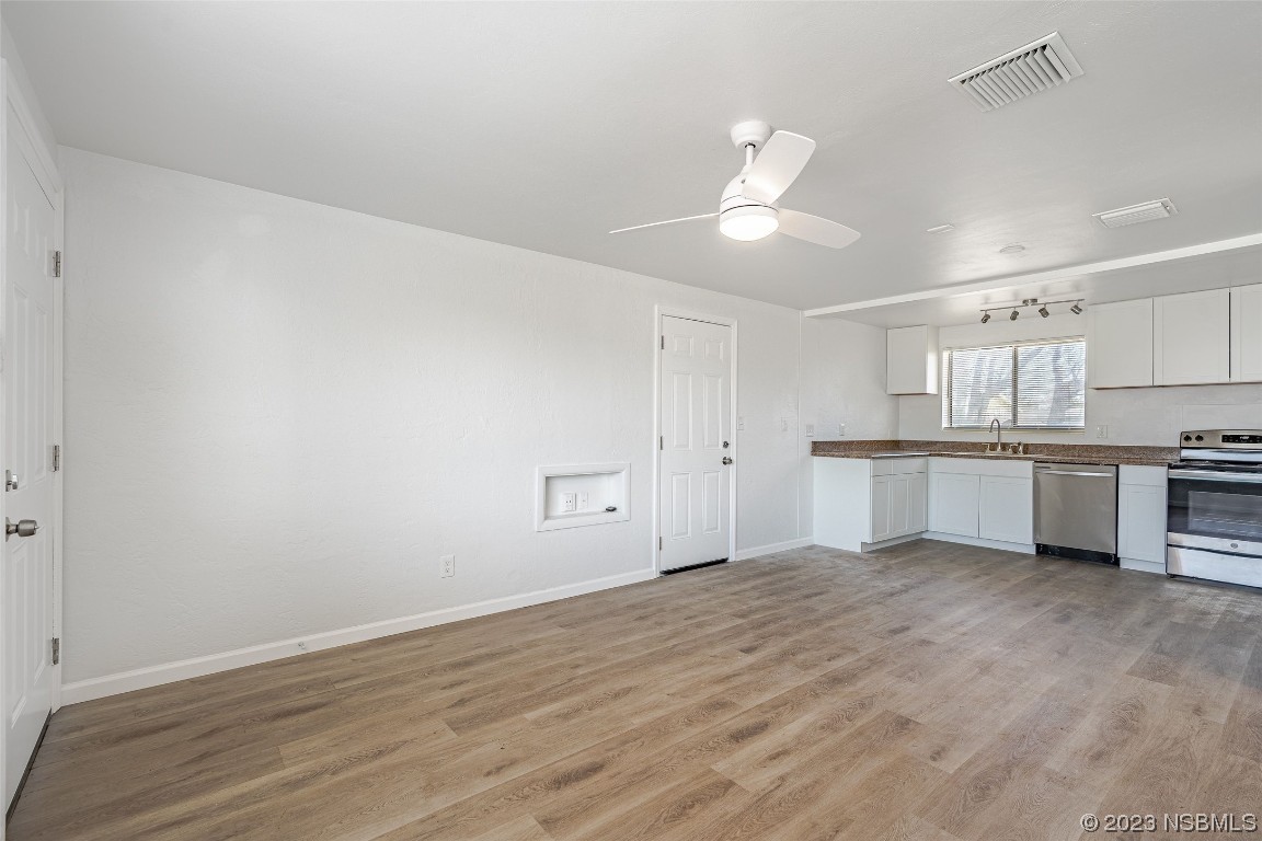 909 Derbyshire Road Daytona Beach, FL 32117 - Photo 8 of 18 a view of kitchen with wooden floor and window