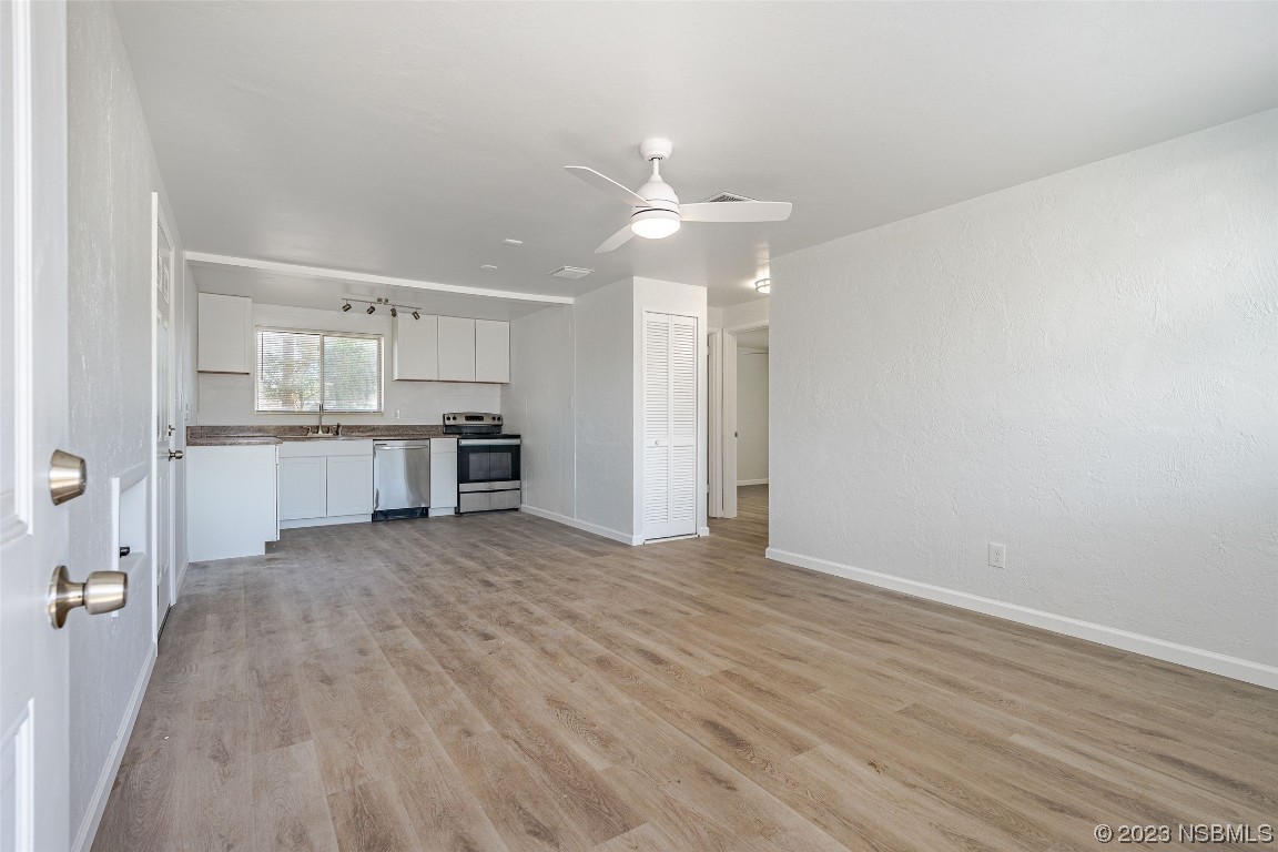 909 Derbyshire Road Daytona Beach, FL 32117 - Photo 9 of 18 an empty room with kitchen and fireplace