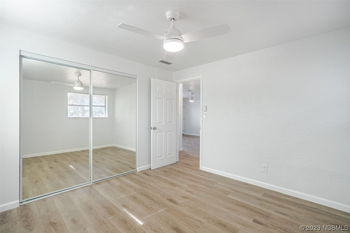 909 Derbyshire Road Daytona Beach, FL 32117 - Photo 10 of 18 a view of an empty room with window and wooden floor