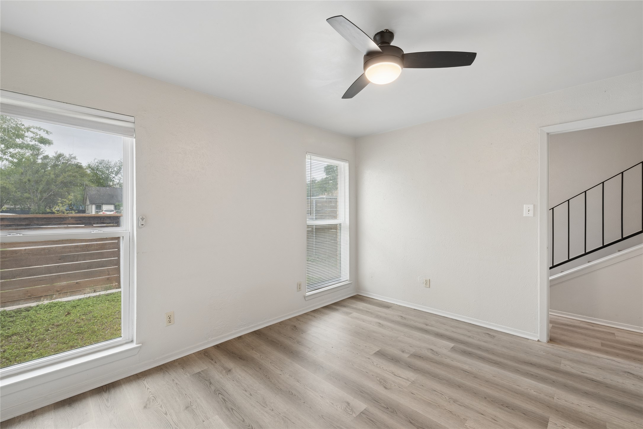 820 Sahara Avenue, Unit B Austin, TX 78745 - Photo 17 of 29 an empty room with wooden floor fan and windows