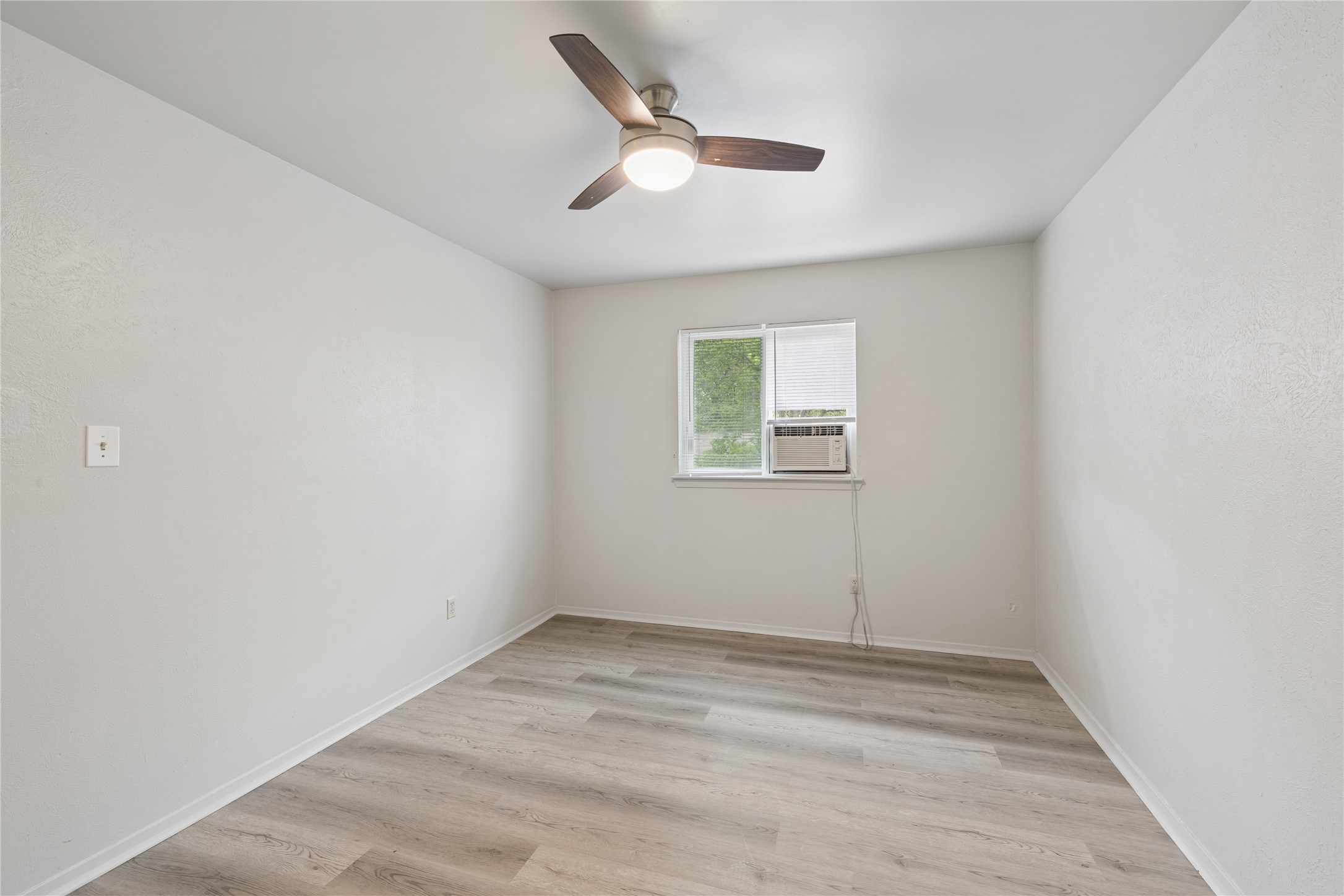 820 Sahara Avenue, Unit B Austin, TX 78745 - Photo 7 of 29 an empty room with a ceiling fan and window