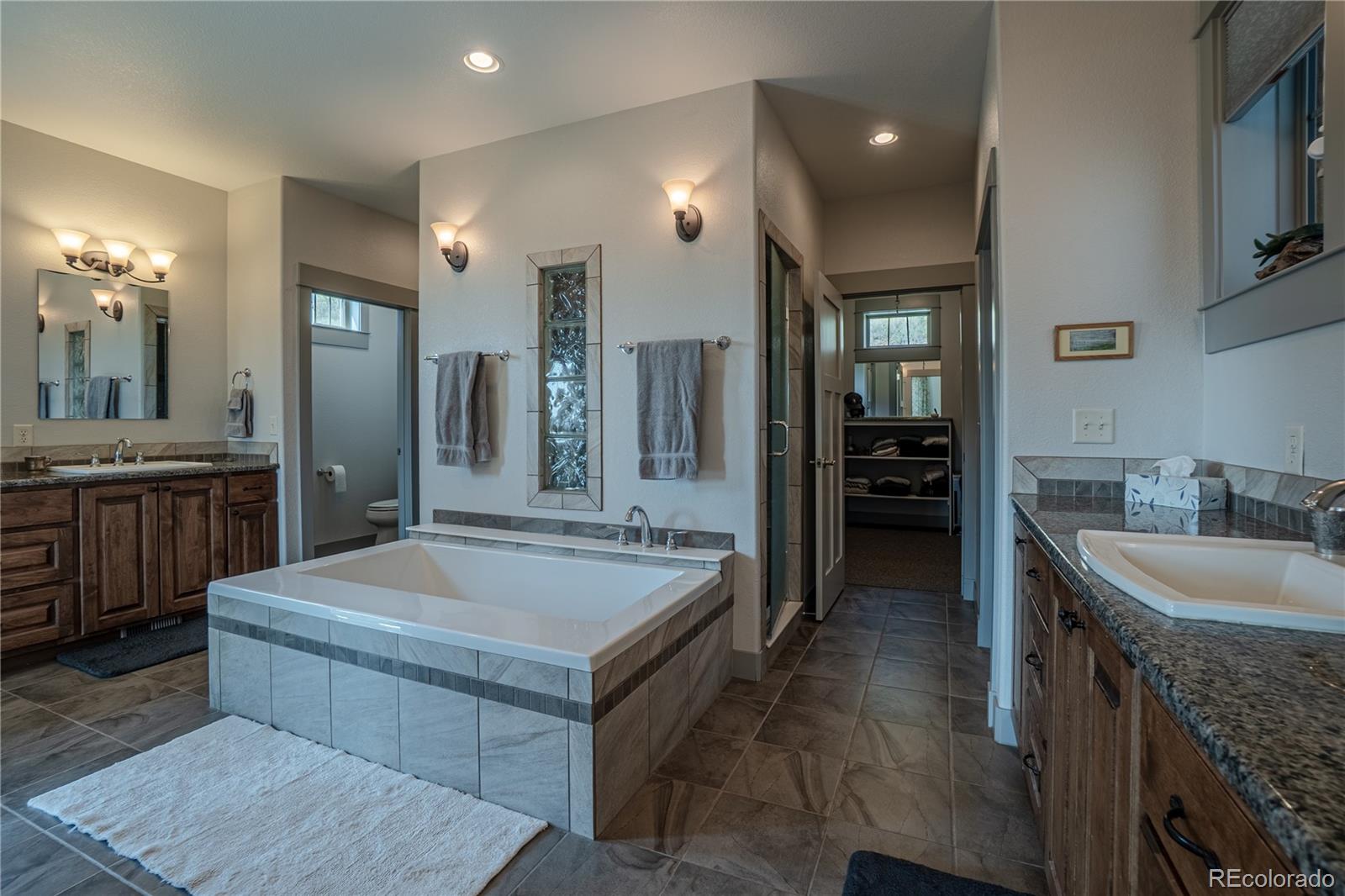 1388 Mt Moriah Road Livermore, CO 80536 - Photo 16 of 40 a large spacious bathroom with a granite countertop sink and a mirror