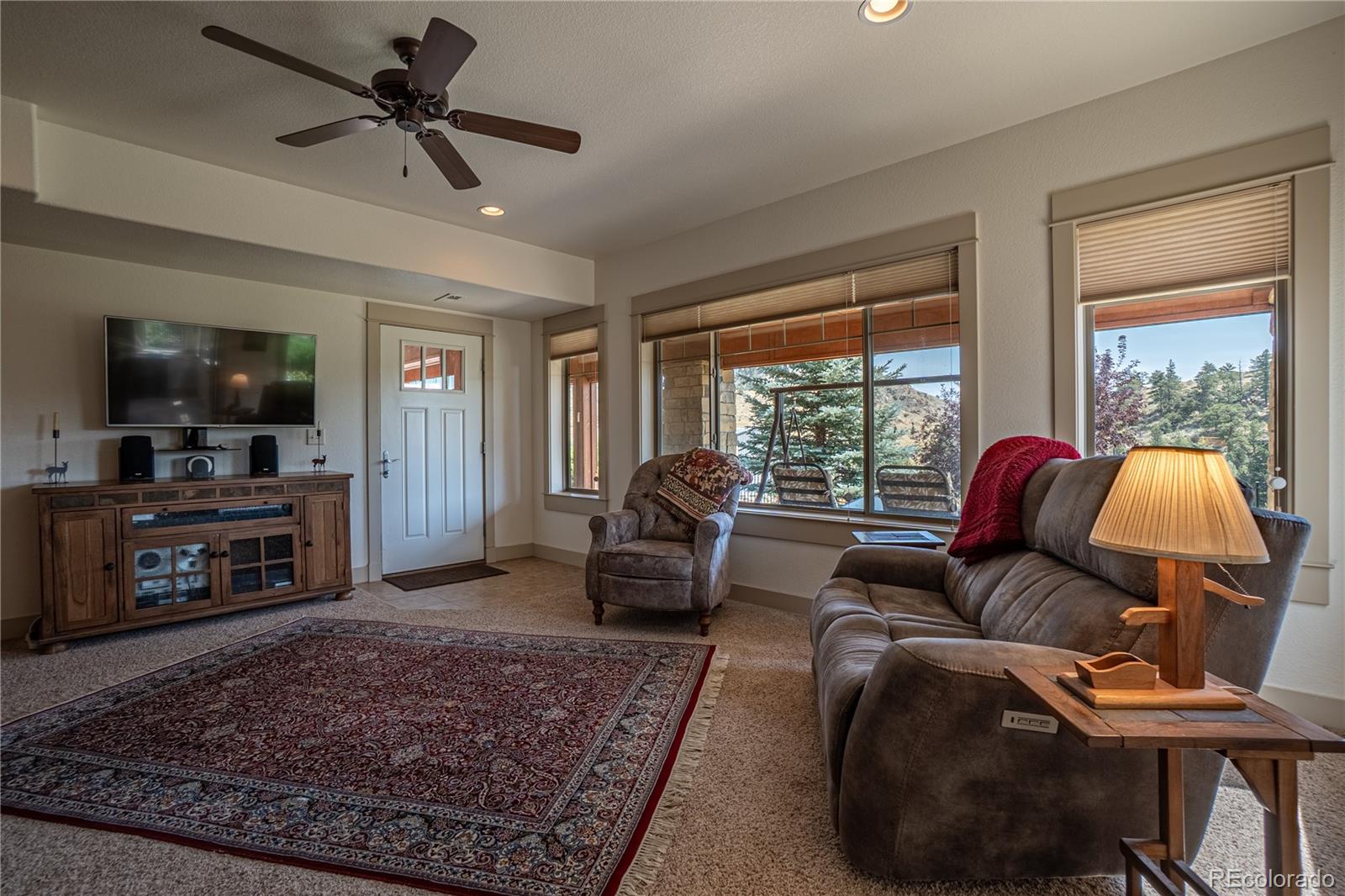 1388 Mt Moriah Road Livermore, CO 80536 - Photo 19 of 40 a living room with furniture a fireplace a flat screen tv and a large window