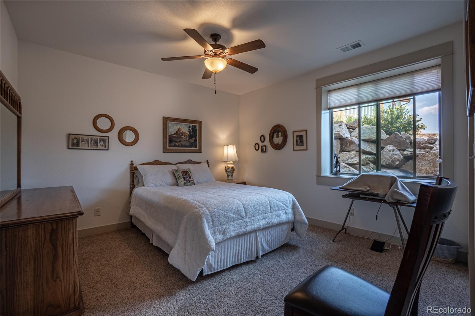 1388 Mt Moriah Road Livermore, CO 80536 - Photo 24 of 40 a bedroom with a bed and a chandelier