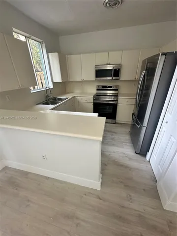 a kitchen with granite countertop a refrigerator stove and sink