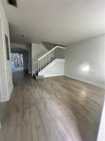 a bathroom with a toilet and a wooden floor