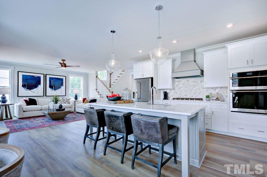 192 DUNLOE Loop Raleigh, NC 27603 - Photo 17 of 19 a kitchen with stainless steel appliances a dining table chairs stove and white cabinets