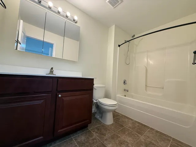 a bathroom with a toilet sink vanity and mirror