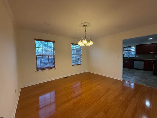 an empty room with wooden floor fireplace and window