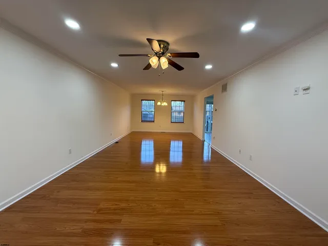 a view of a room with window ceiling fan and wooden floor