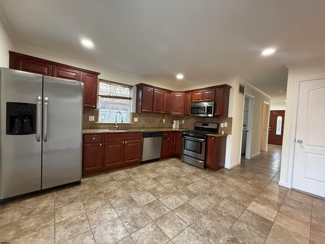 a kitchen with stainless steel appliances granite countertop a refrigerator and a sink