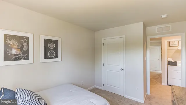 a bedroom with a bed and painting on the wall