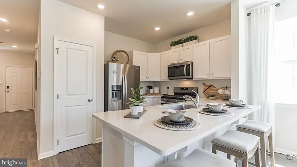 a kitchen with sink refrigerator dining table and chairs