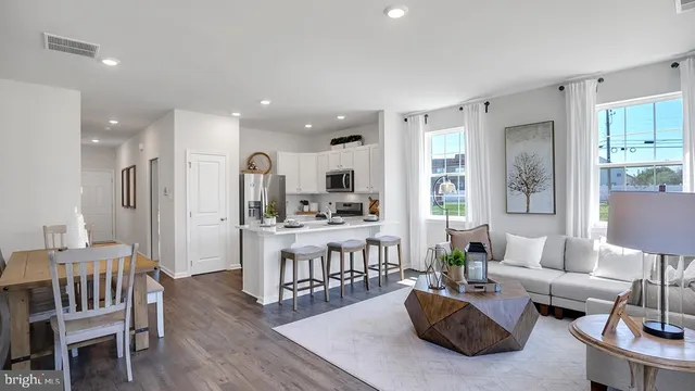 a living room with furniture and a dining table with wooden floor