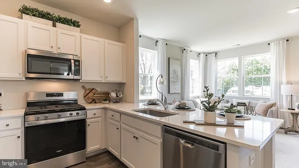 a kitchen with stainless steel appliances a sink a stove a microwave and cabinets