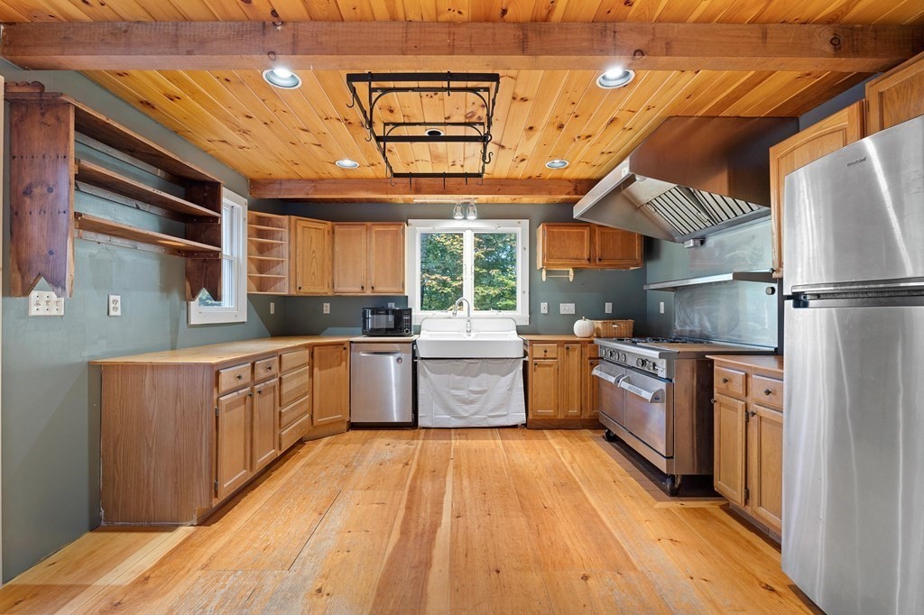 756 Bemis Road Warren, MA 01585 - Photo 11 of 41 a kitchen with granite countertop a refrigerator and wooden cabinets